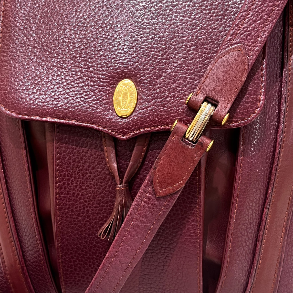 Cartier Burgundy Flap Backpack with Tassel Detail — emblem tassel and strap