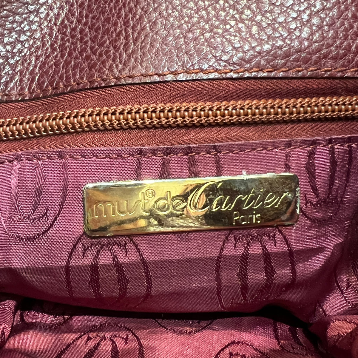 Cartier Burgundy Flap Backpack with Tassel Detail — interior brand plaque