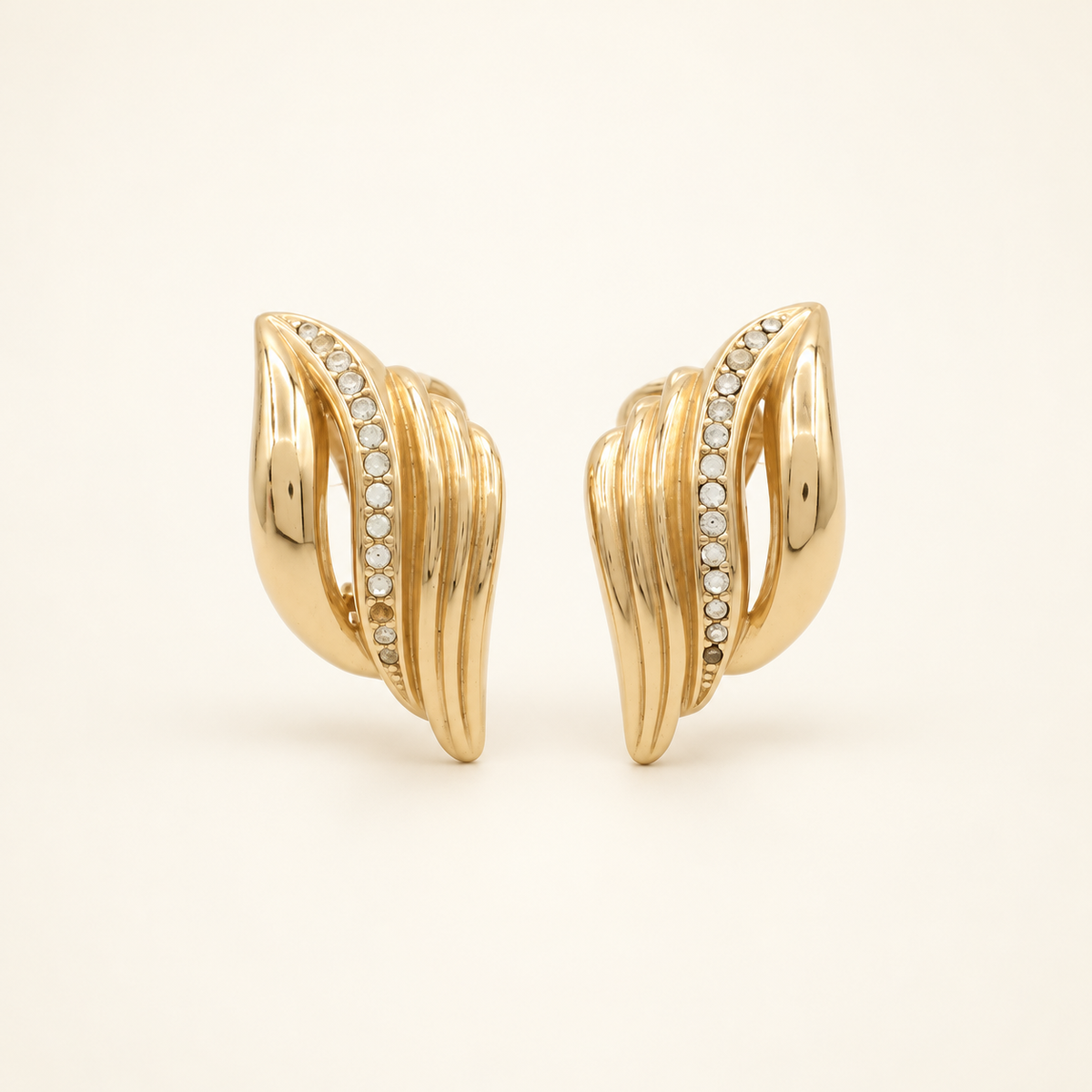 Christian Dior Gold-Plated Ribbed Rhinestone Clip-On Earrings — front view on an ivory background