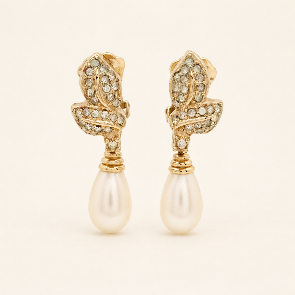 Christian Dior Gold-Tone Faux Pearl Teardrop Clip-On Earrings — front view on an ivory background