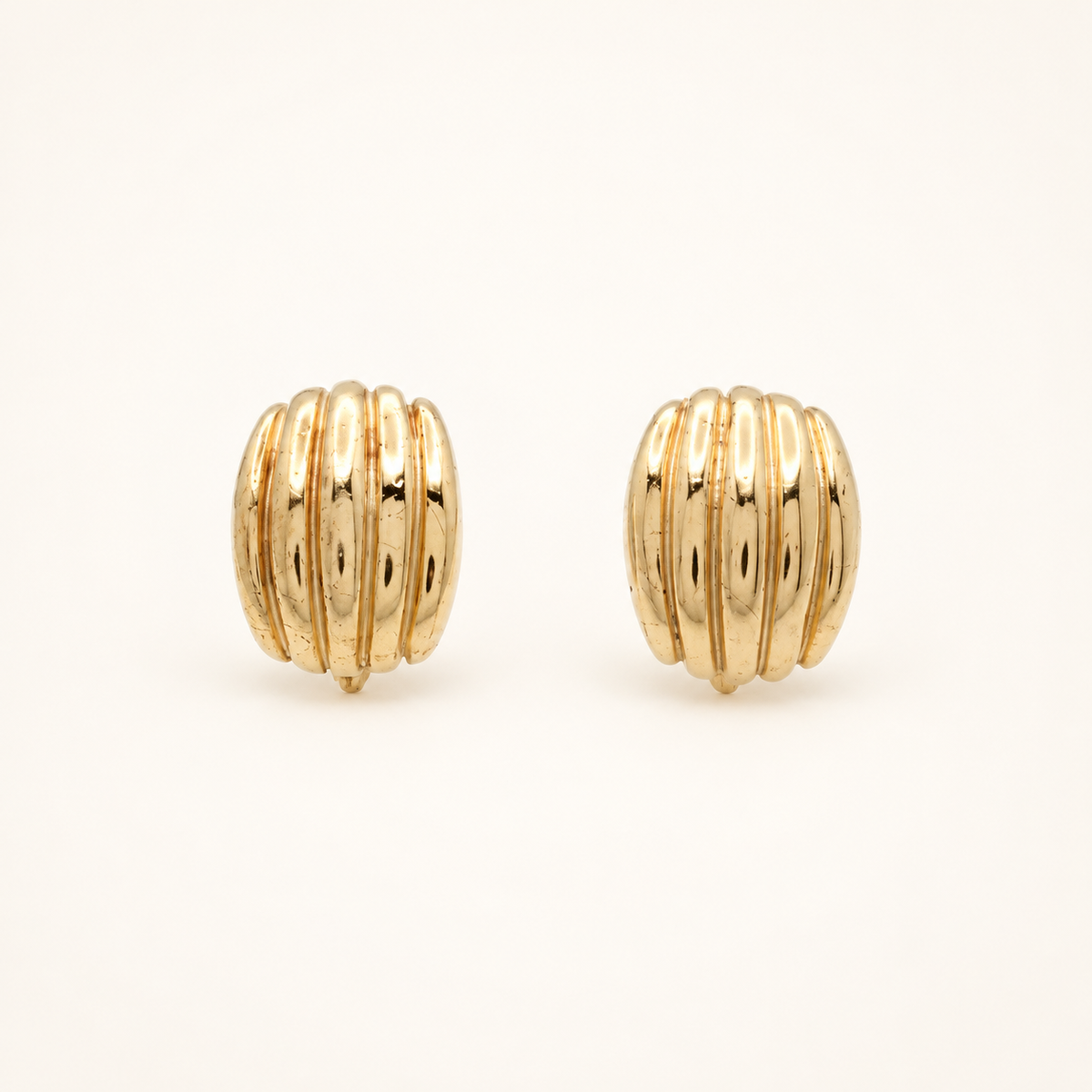 Christian Dior Gold-Tone Ribbed Half-Hoop Clip-On Earrings — front view on an ivory background