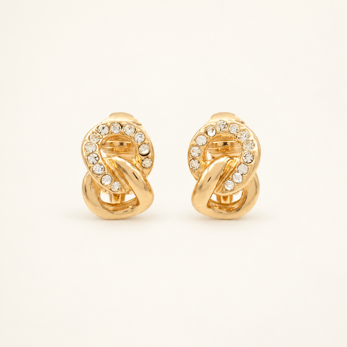 Christian Dior Gold-Tone Scroll Rhinestone Clip-On Earrings — front view on an ivory background