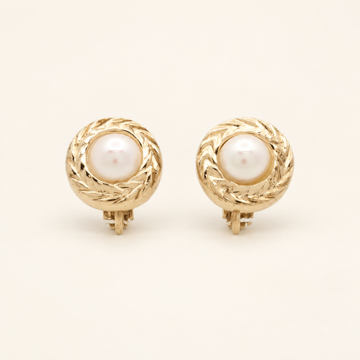 Christian Dior Gold-Tone Round Faux Pearl Clip-On Earrings — front view on an ivory background