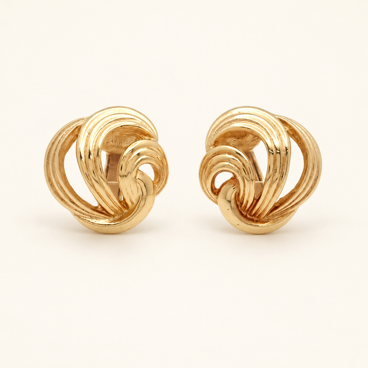 Christian Dior Gold-Plated Open Knot Clip-On Earrings — front view on an ivory background