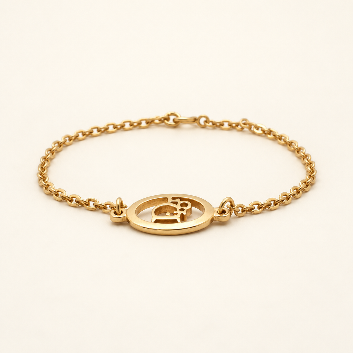 Christian Dior Gold-Tone Oval CD Chain Bracelet, 17cm — front view on an ivory background