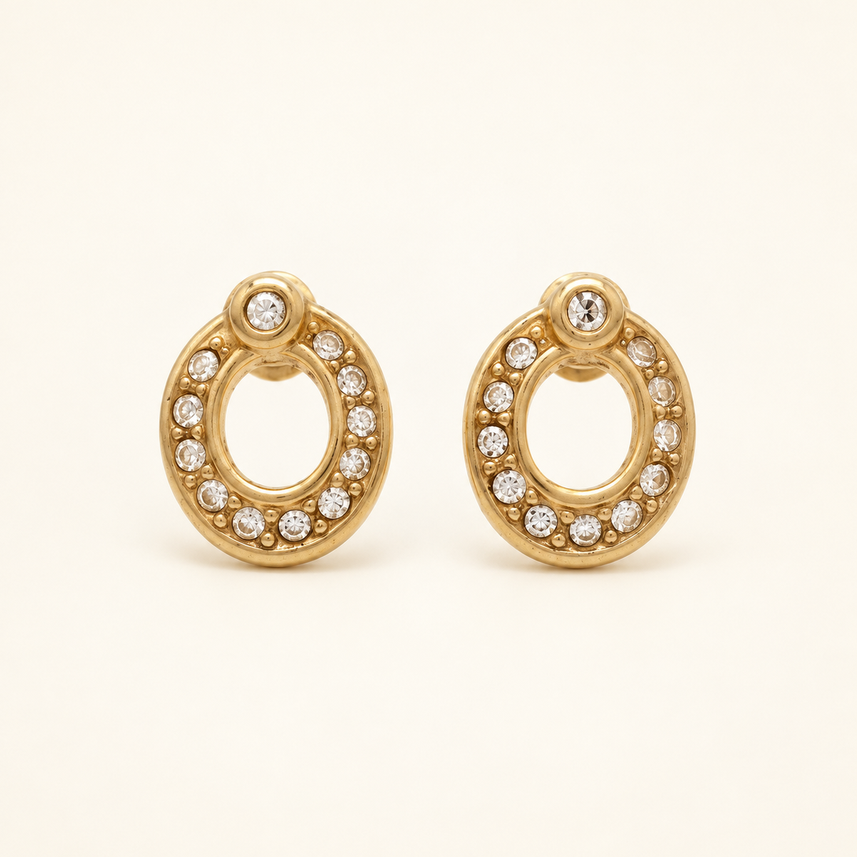 Christian Dior Gold-Tone Oval Rhinestone Drop Earrings — front view on an ivory background