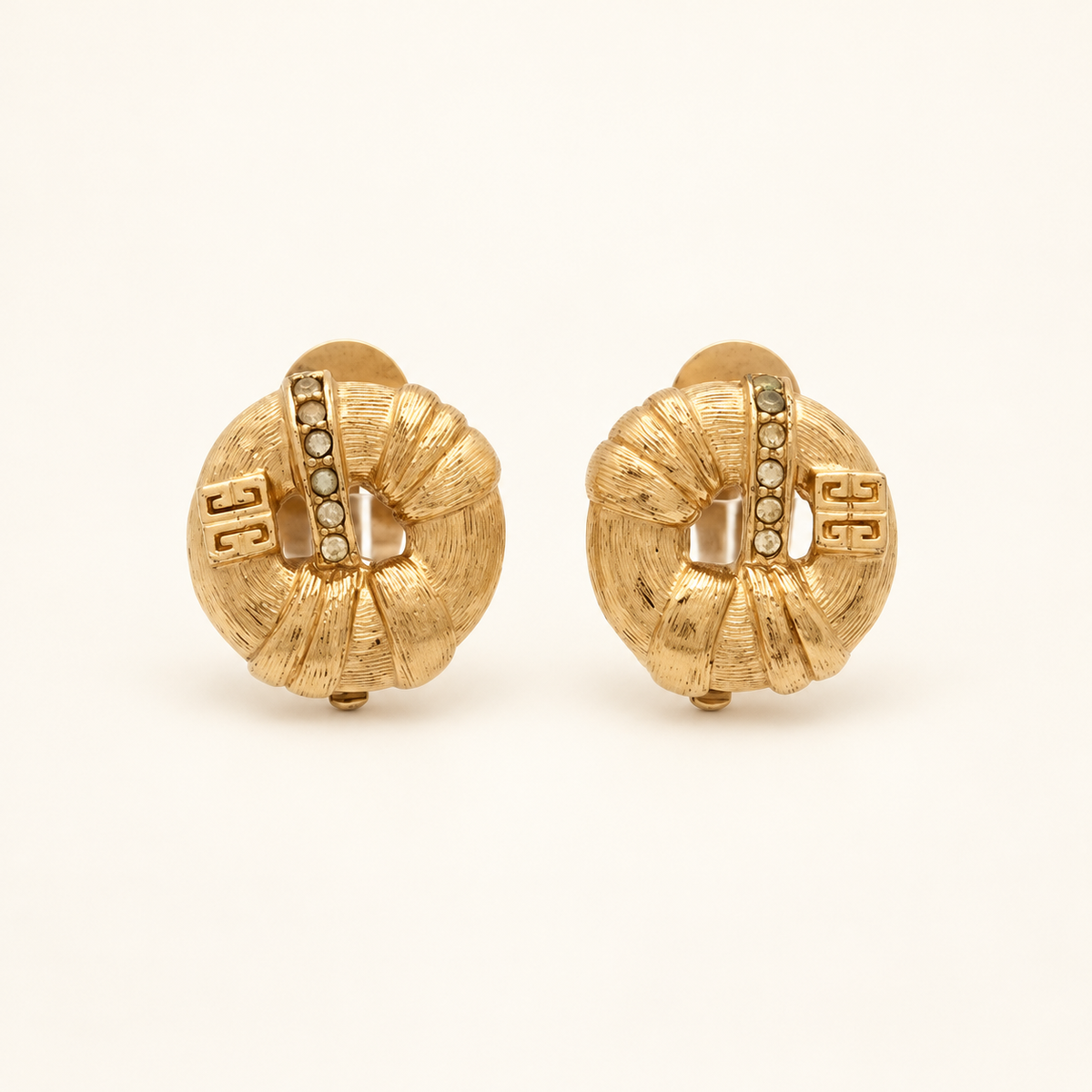 Givenchy Gold-Tone Textured Logo Clip-On Earrings — front view on an ivory background