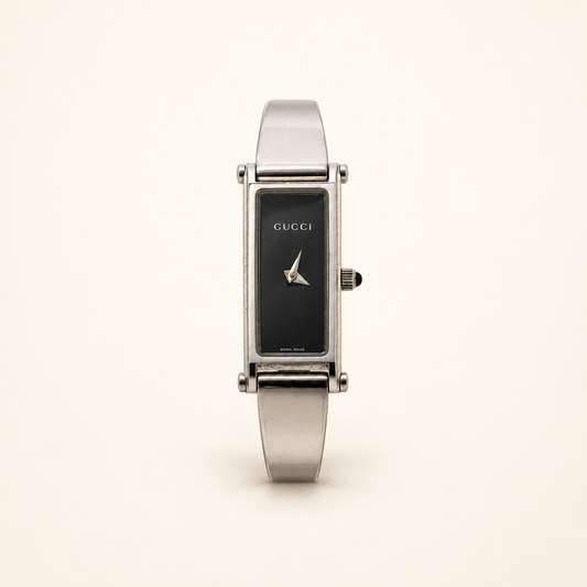 Gucci 1500L Black Dial Quartz Bangle Watch — front view on an ivory background