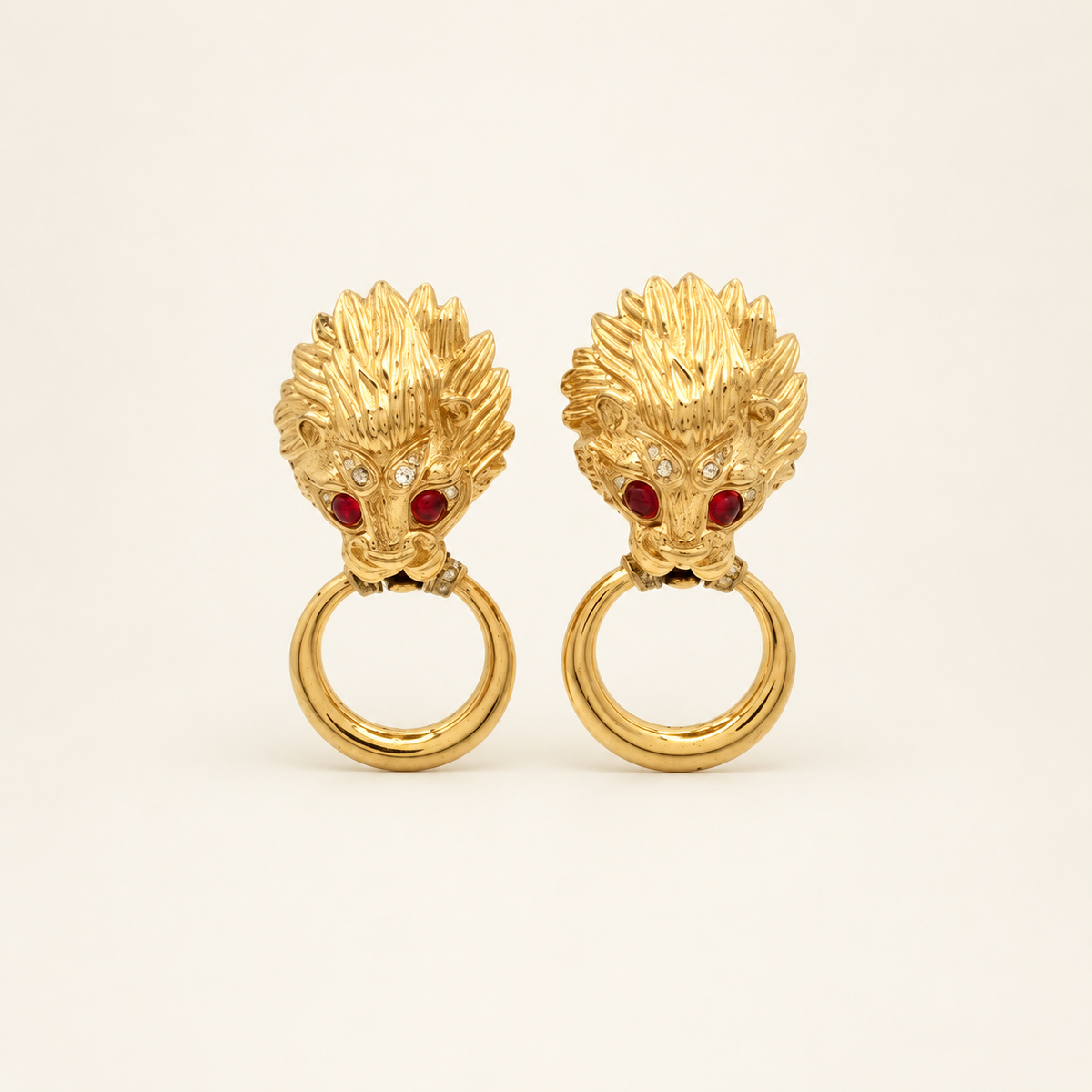 Nina Ricci Gold-Tone Lion Head Ring Drop Clip-On Earrings — front view on an ivory background