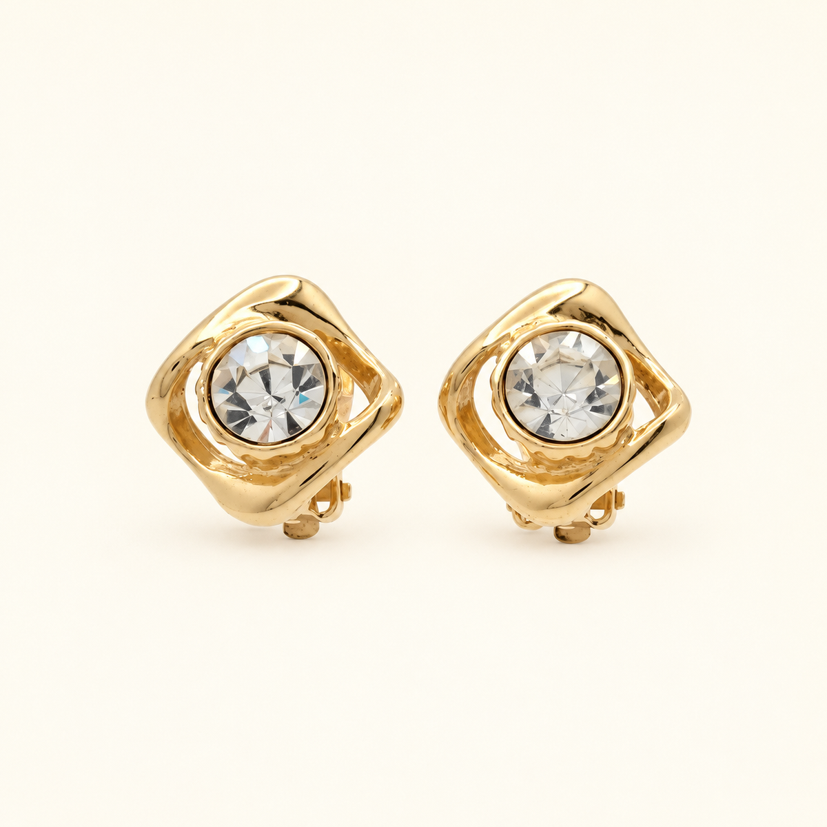 Yves Saint Laurent Gold-Plated Clear Stone Clip-On Earrings — front view on an ivory background